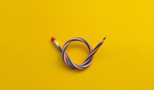 rubber pencil tied in a not on a bright yellow background