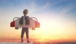 Courtyard Adventures image, a young girl wearing a homemade jet pack looks out over a sunset