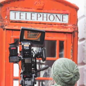 A camera set up in front of a red telephone box