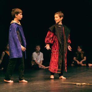 Two young boys dressed in robes acting out a Shakespeare scene