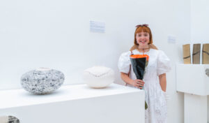 Sophie Campbell stood next to art at the exhibition 