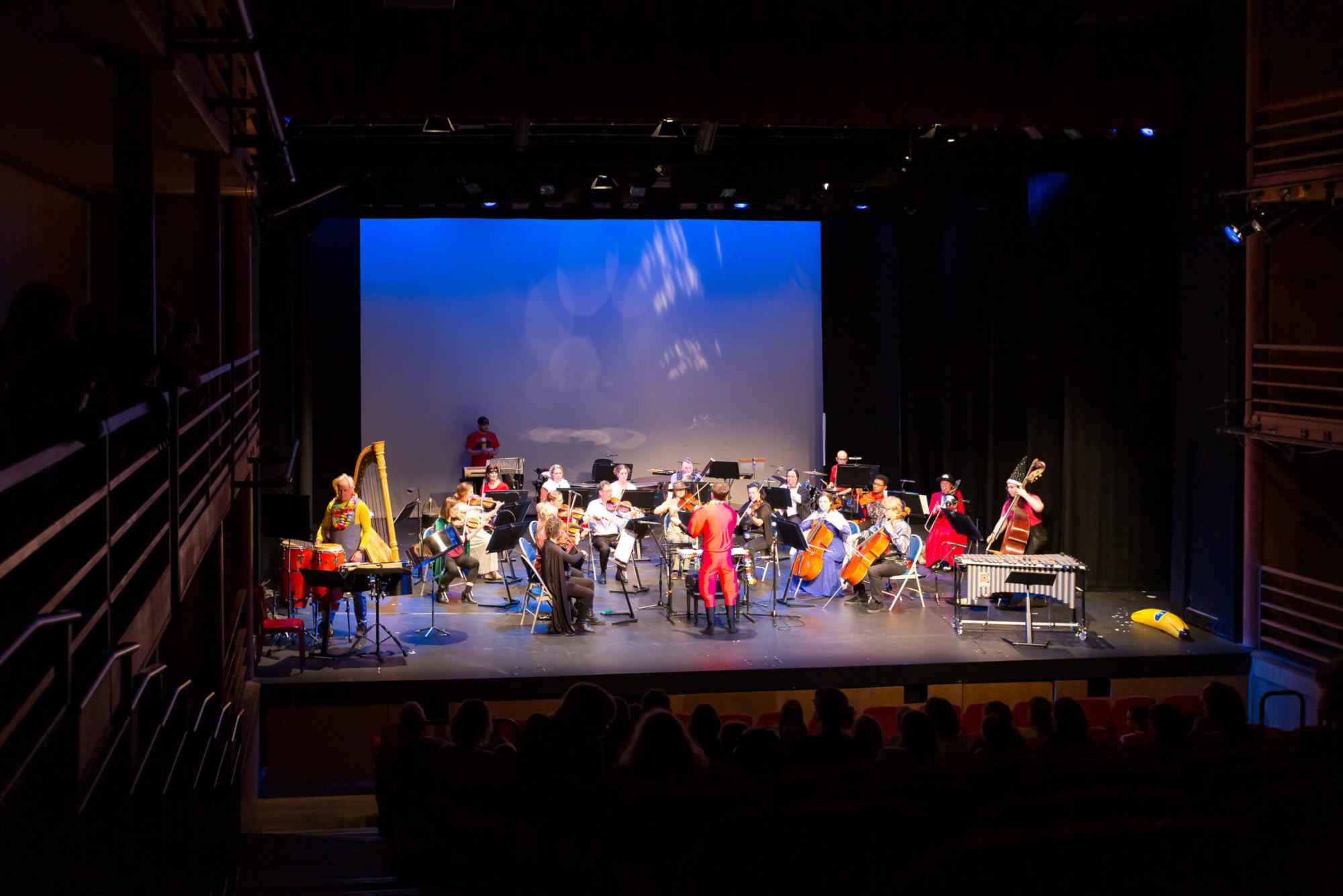 Orchestra Of The Swan brings movie magic to The Courtyard: An orchestra playing in fancy dress onstage in front of an audience