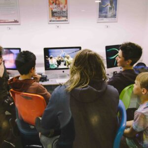 Film club members sitting round a computer, editing film footage