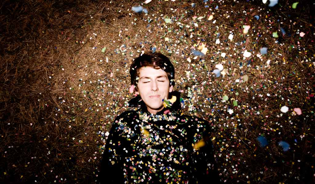 A man lying on the ground surrounded by confetti