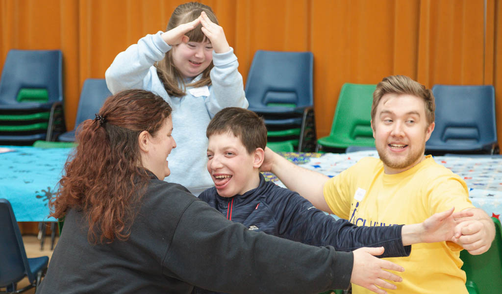 Two young people with learning disabilities with two workshop leaders making a sculpture with their bodies