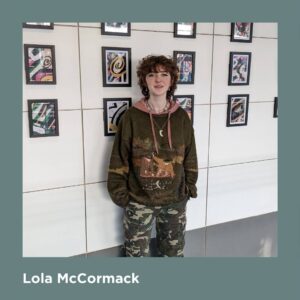 Artist Lola McCormack standing in front of an exhibition 