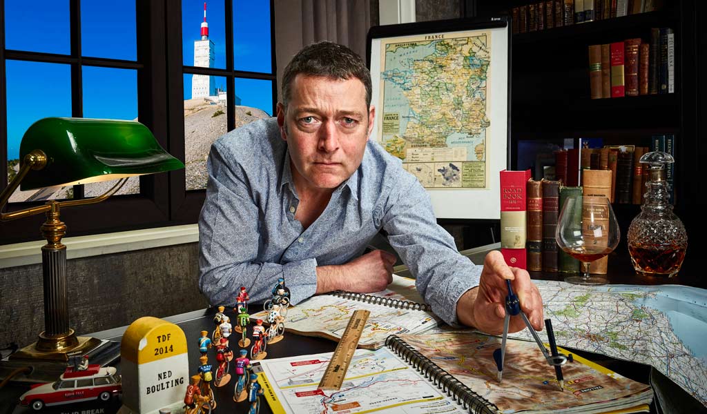 Ned Boulting looking serious leaning over some maps and holding a compass
