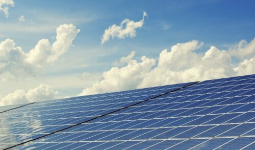 Solar panels against a blue clouded sky