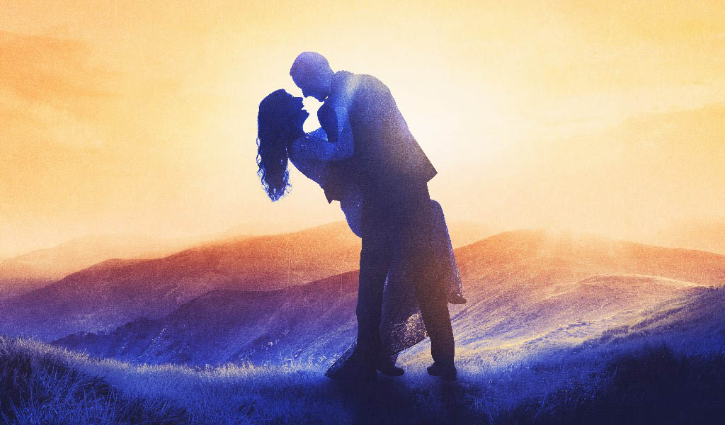 An illustration of a couple in each other's arms surrounded by purple mountains and a sunset