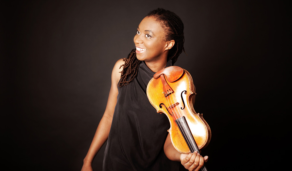 Tai Murray smiles whilst holding a Violin