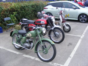 Three vintage motorbikes in a car park
