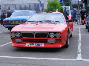 A vintage lancia car in red in a car park