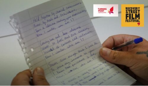 Image A person holds a hand written note in front of the camera