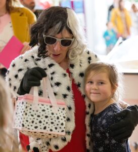 Fundraising Manager Clare Wichbold dressed up as Cruella Deville, with her arm around a little girl