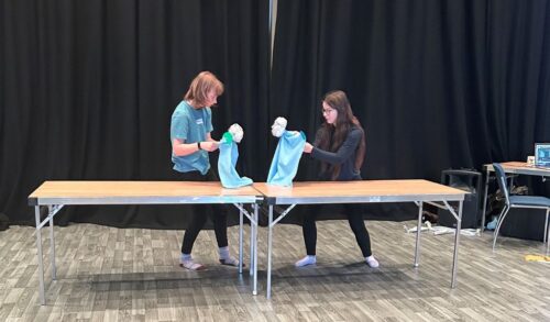 Two Youth Theatre members taking part in a puppetry workshop