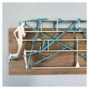 A wooden sculpture depicting a person running. Blue rope is intertwined with the wood.