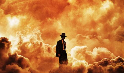 A silhouette of a man in a suit and hat is visible amongst a large orange cloud