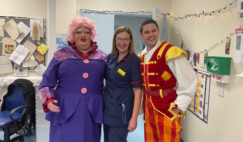 Two panto cast members smiling next to a nurse