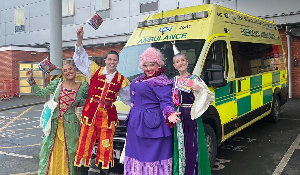 The panto cast posing in front of an ambulance