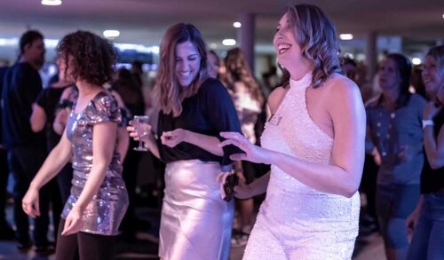 Three women laughing and dancing at The Courtyard