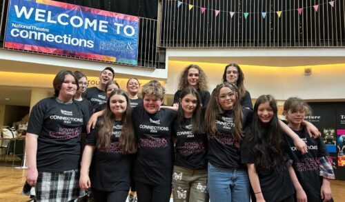 A group of young people stood smiling in a group in branded tshirts