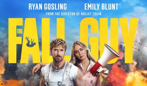 Emily blunt stands with a megaphone and one arm around the shoulder of Ryan Gosling There is fire and smoke in the background around the films title The Fall Guy