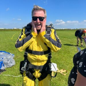 A picture of a man in a skydive suit looking scared