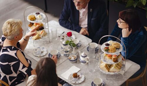 A group of four people sat at a table enjoying afternoon tea