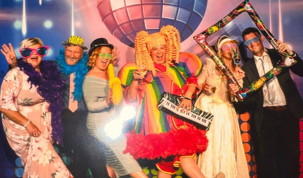 Six people posing for the camera with different props.
