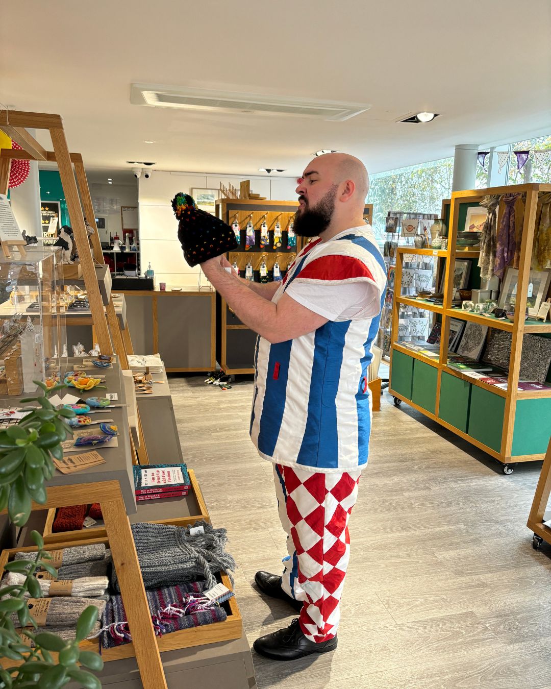 A pantomime cast member in costume looking at a bobble hat.