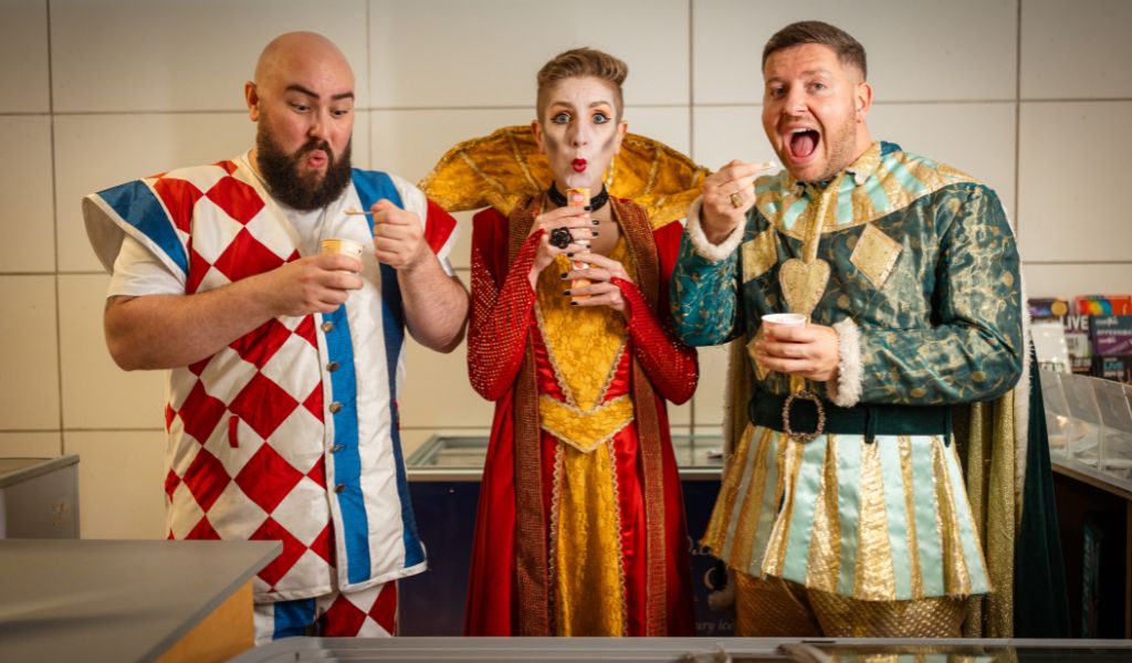 Three panto characters stand in a line posing with ice creams.