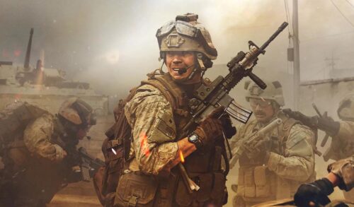 A man in full military gear and camouflage stands in a cloud of dust Other soldiers can be seen behind him