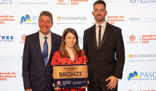 A Group Of Award Winners Smiling And Posing With Their Plaque On Stage At A Gala Ceremony