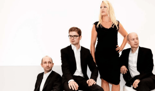 A group of musicians in formal wear posing together