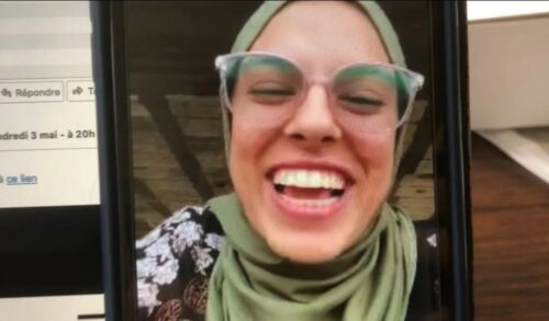 A closeup image of a woman smiling on a mobile phone video call