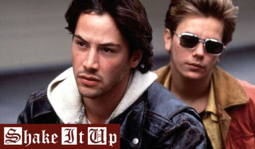 Two men ride on the back of a motorbike In the bottom left is the title Shake It Up