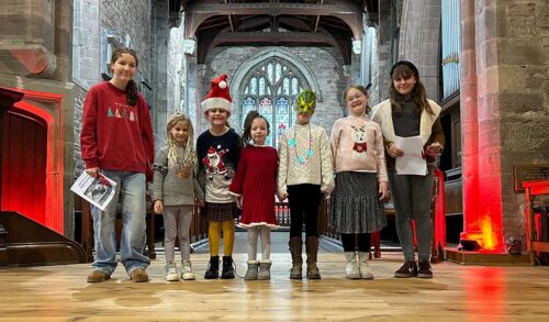 A group of children smiling inside of a church