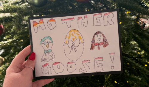 A hand holding an illustration of a goose an egg and a lady with text above and below that reads Mother Goose