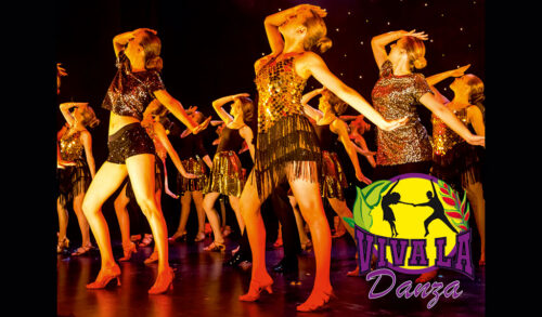 An image of dancers in gold dresses posing on stage The logo in the bottom right has a silhouette of two dancers The text underneath reads Viva La Danza