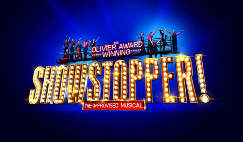 Light up letters that spell out Showstopper The Improvised Musical with a walkway above with people standing and holding their hands in the air The text above the walkway reads The Olivier Award Winning
