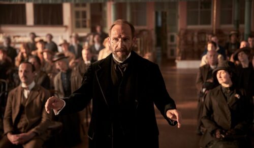 The Choral  Ralph Fiennes stands in a hall of people